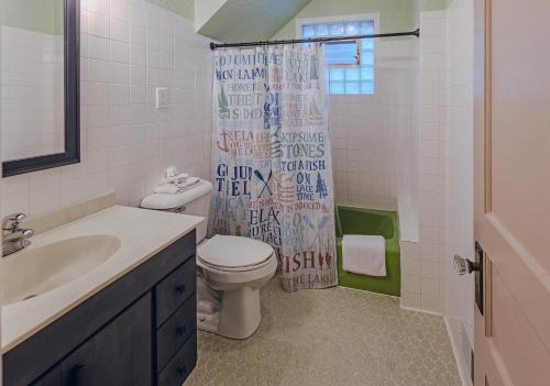 ein Bad mit einem WC und einem Duschvorhang in der Unterkunft Sunrise Shores Retreat in Three Lakes WI in Three Lakes