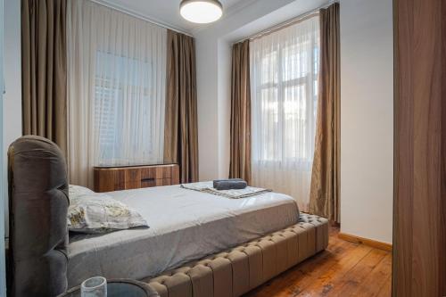Un dormitorio con una cama y una ventana grande. en GALLERY RUSE CENTER, en Ruse