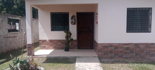 El Porvenir的住宿－Casa Pico Bonito，一座有盆栽植物的房子的前门