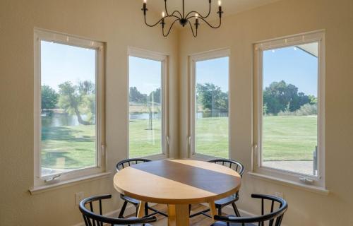 a dining room with a table and chairs and windows at Riverfront Beauty with Pickle Ball Court in Kingsburg
