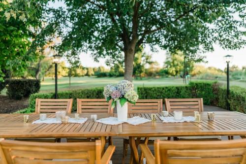 a wooden table with a vase of flowers on it at Riverfront Beauty with Pickle Ball Court in Kingsburg