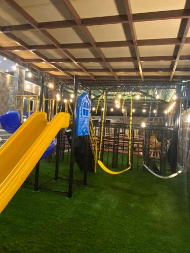 a playground with a slide and swings at Bait Alsalam in Sayq