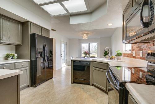 a large kitchen with a refrigerator and a sink at Tranquil Fort Wayne Home 7 Mi to Downtown in Fort Wayne