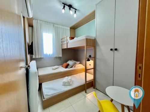 Kleines Zimmer mit 2 Etagenbetten und einem Tisch in der Unterkunft Apto 3 Quartos em Home Club com telas de Proteção in Penha