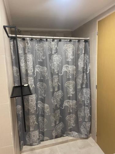 a shower curtain with a pattern of umbrellas at Florencia in Termas de Río Hondo
