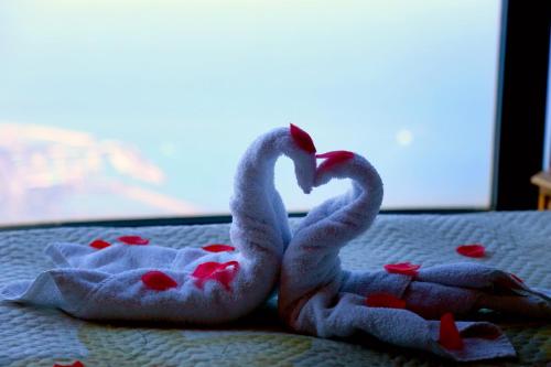 two towels shaped like swans sitting on a bed at Bay Lodge Boutique Hotel in Jounieh