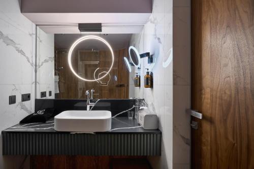 a bathroom with a sink and a round mirror at F&B Spa Resort (ex. Fomich Hotel) in Bukovel