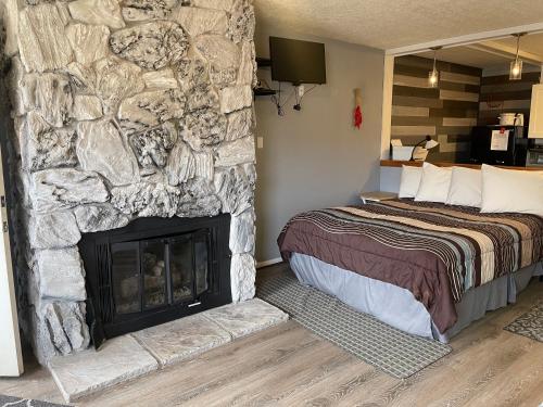 um quarto com uma parede de pedra, uma cama e uma lareira em Riverbend 8 - Full Property em Red River