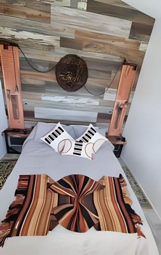 1 dormitorio con 1 cama con pared de madera en Okeyloft Coyhaique 4, en Coyhaique