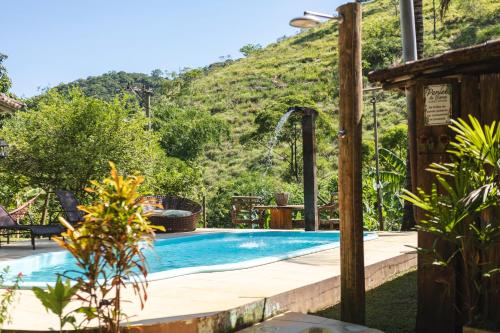 a swimming pool with a mountain in the background at Peniel do Sana Guest House in Sana