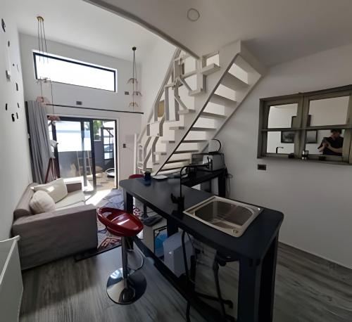 a living room with a staircase and a desk in it at okeyloft Coyhaique 5 in Coihaique