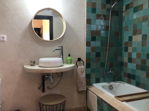a bathroom with a sink and a mirror and a tub at Atlas Views By Golf Resort in Marrakesh