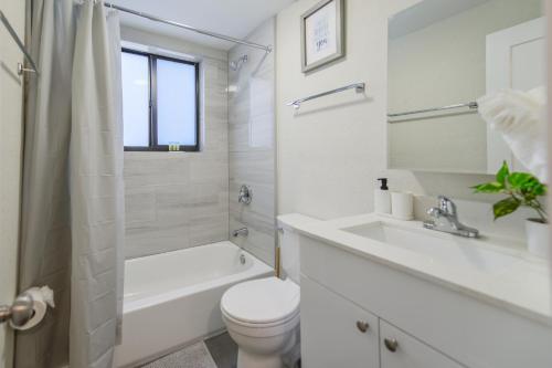 biała łazienka z toaletą i umywalką w obiekcie Apartment in Calle Ocho a Slice of Little Havana w Miami