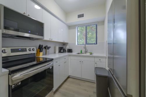 a kitchen with white cabinets and a stainless steel refrigerator at Apartment in Calle Ocho a Slice of Little Havana in Miami