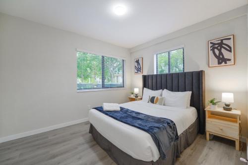 a bedroom with a large bed and two windows at Apartment in Calle Ocho a Slice of Little Havana in Miami