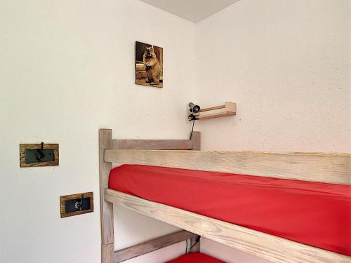 Ce lit superposé se trouve dans un dortoir avec 2 photos sur le mur. dans l'établissement Appartement lumineux en centre station avec balcon et accès piscine - FR-1-267-200, au Corbier