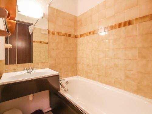 een badkamer met een wit bad en een wastafel bij Appartement La Rosière, 2 pièces, 6 personnes - FR-1-275-170 in La Rosière
