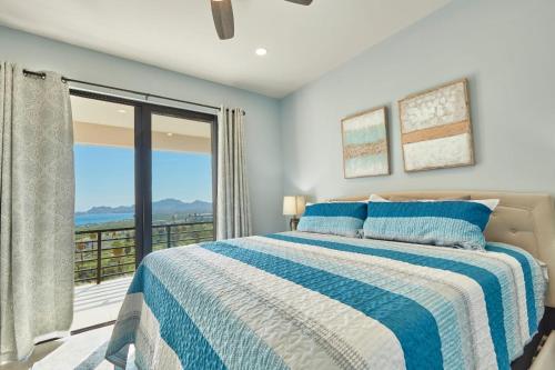1 dormitorio con cama y ventana grande en Casa El Ocaso en Cabo San Lucas