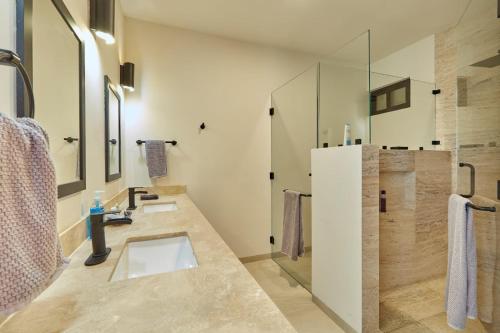 a bathroom with two sinks and a shower at Casa El Ocaso in Cabo San Lucas
