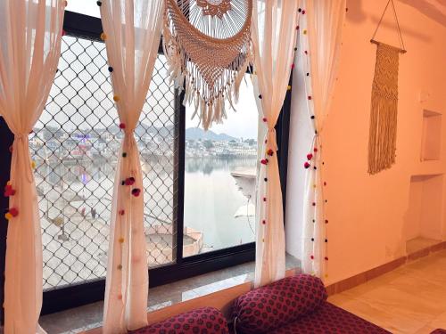 a room with a window with a view of the water at Hotel Kota kunj Heritage in Pushkar