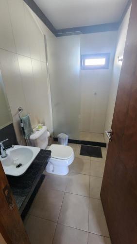 a bathroom with a white toilet and a sink at Departamento Centro San Rafael in San Rafael