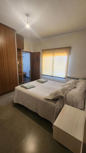 聖拉斐爾的住宿－Departamento Centro San Rafael，一间卧室设有一张大床和一个窗户。