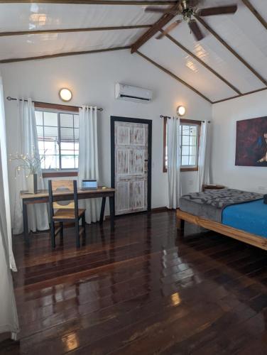 a bedroom with a bed and a desk and a table at Barrbra BnB Over The Sea in Bocas del Toro
