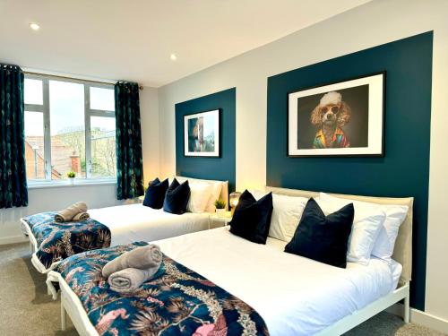 2 camas en una habitación con paredes azules en Incredible Large 3 Bedroom Apartment - Sleeps 8!, en Bournemouth