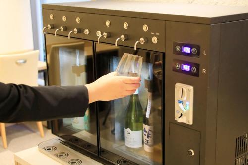 a person holding a glass of wine in an oven at Richmond Hotel Utsunomiya-ekimae Annex in Utsunomiya