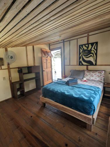 a bedroom with a large bed with a wooden ceiling at Barrbra BnB Over The Sea in Bocas del Toro