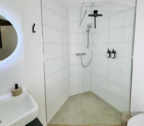a shower with a glass door next to a sink at Bunker-Studio Zentral Business Messe in Essen