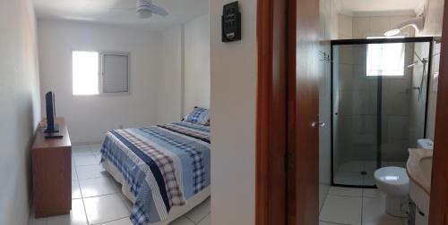 a bedroom with a bed and a glass shower at Max House PG -Novo, 82m2, Guilhermina, Churrasqueira e prox a feirinha in Praia Grande