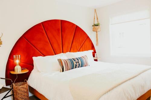 a bedroom with a large bed with a red headboard at New Downtown Hailey Condo with Rooftop Hot Tub in Hailey