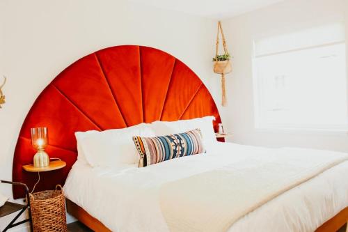 a bedroom with a large bed with a red headboard at New Downtown Hailey Condo with Rooftop Hot Tub in Hailey
