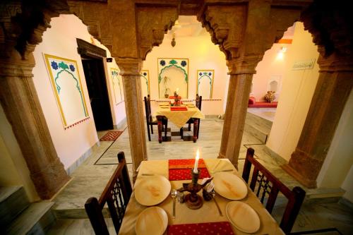- une salle à manger avec une table et une bougie dans l'établissement Bundi Inn - A Heritage Boutique Haveli, à Bundi