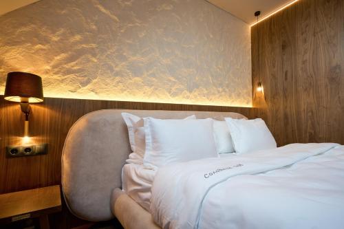 a bedroom with a white bed with a chair at F&B Spa Resort (ex. Fomich Hotel) in Bukovel
