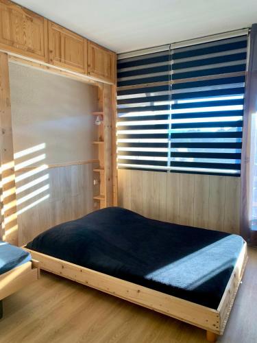 une chambre avec un lit dans une pièce avec une fenêtre dans l'établissement Studio Cabine Chaleureux 4 Personnes Pied des Pistes Pyrénées 2000, à Bolquère-Pyrénées 2000