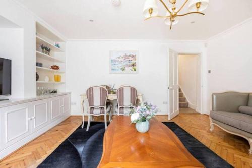 ein Wohnzimmer mit einem Tisch, Stühlen und einem Sofa in der Unterkunft Affordable, Secluded Flat in Central London in London