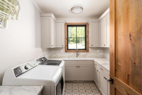 eine weiße Küche mit einem Waschbecken und einem Fenster in der Unterkunft The Sheepbend Home - Luxury Home Steps to River! in Bellevue