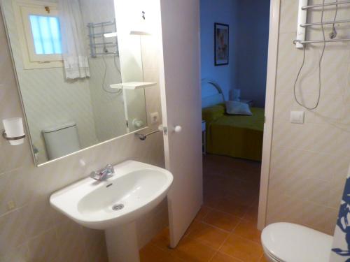 a bathroom with a sink and a toilet and a mirror at Apartamento Playa in S'Agaro