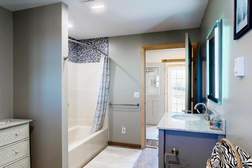 a bathroom with a tub and a sink and a shower at The Gambrel House in Pulteney