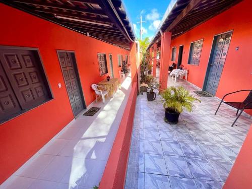 pusty dziedziniec budynku z czerwonymi ścianami w obiekcie Graos de Areia Pioneira w mieście Mangue Sêco