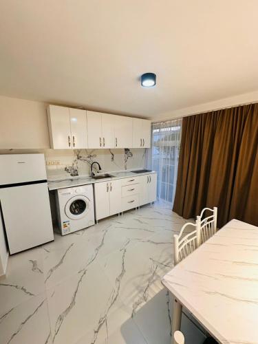 a kitchen with white appliances and a marble floor at villa gardens in K'obulet'i