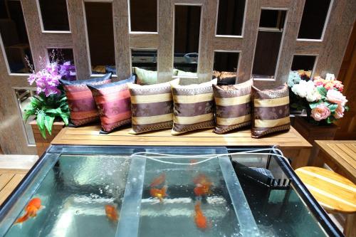 バンコクにあるタニー プレイスの池の横のテーブルに座る枕