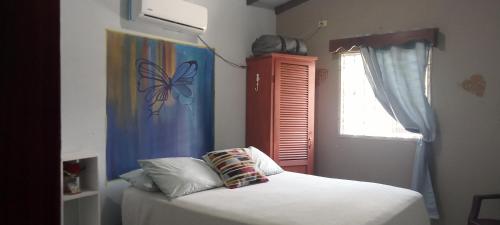 a bedroom with a bed and a window with a butterfly curtain at Casa Pico Bonito 