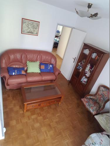 a living room with a leather couch and a coffee table at Belle Appartement in Auxerre