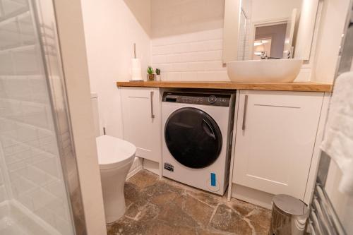 a bathroom with a washing machine and a sink at One-bed flat Angel, Islington in London