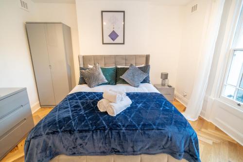 a bedroom with a blue bed with towels on it at One-bed flat Angel, Islington in London