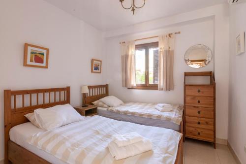Un dormitorio con dos camas y una ventana. en Marina d'Or III - Villa 10, en Santanyí