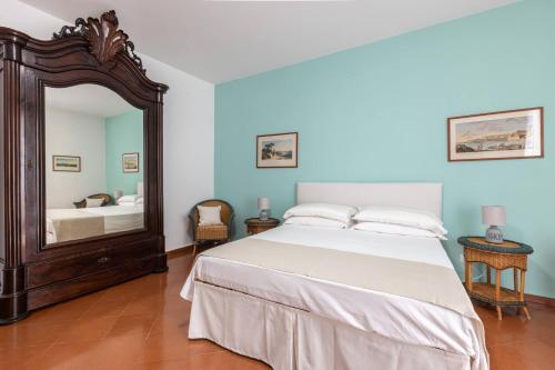 1 dormitorio con 1 cama grande y espejo en Charming bedroom in Sorrento with balcony, en Sorrento